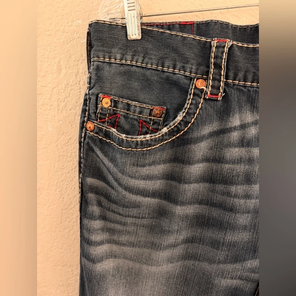 True Religion jeans feature a dark wash and bold signature stitching. Skinny